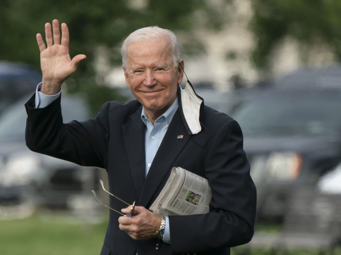 President Biden waves as he crosses the White House lawn.