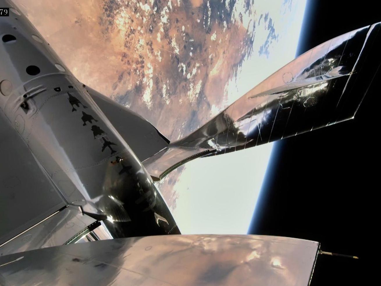 The wing of an orbiting spaceship with Earth and black space behind it.
